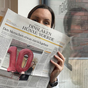 Abgebildet wird Christina Goldenhaus mit einem Zeitungsartikel in der Rheinischen Post